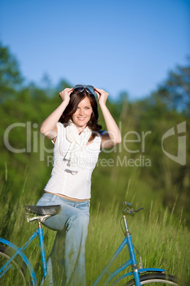 Woman with old-fashioned bike in summer meadow