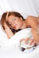 White lounge - Tired woman holding alarm clock