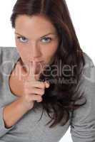 Beautiful woman expressing silence, finger on lips
