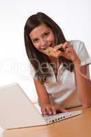 Happy teenager with laptop eating protein bar