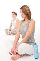 Fitness - Healthy couple stretching after training on white