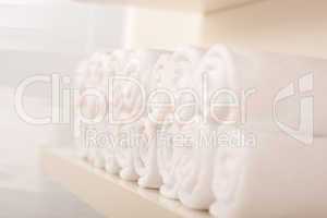 Line of rolled up white bath towels