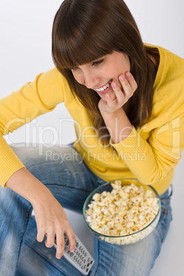 Happy female teenager watching television