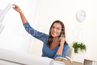 Female architect on the phone sitting at the office