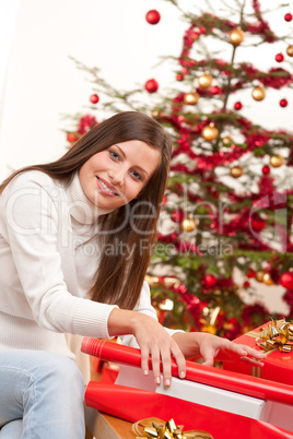 Happy woman wrapping Christmas present