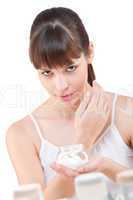 Body care: Young woman with jar of moisturizer in bathroom