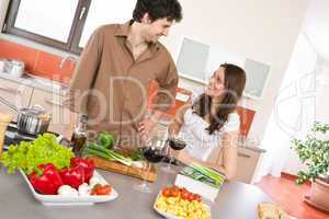 Happy couple in modern kitchen with red wine