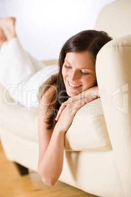 Smiling woman lying down on sofa