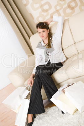 Smiling business woman with shopping bag on sofa