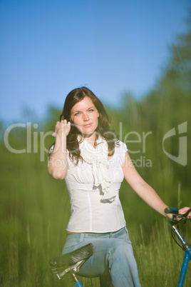 Woman with old-fashioned bike in summer meadow