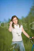Woman with old-fashioned bike in summer meadow