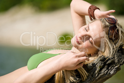 Blond woman relax in bikini at lake