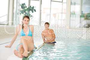 Swimming pool - young couple relax on poolside