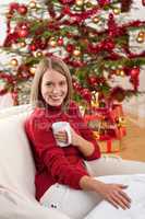 Blond smiling woman in front of Christmas tree