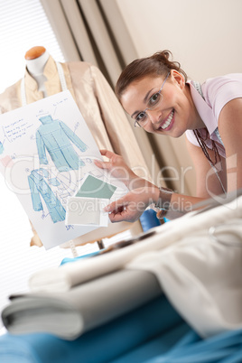 Female fashion designer working at studio with pattern cuttings