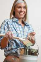 Home improvement: Smiling woman holding can and brush