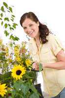 Gardening - smiling woman with sunflower and pruning shears
