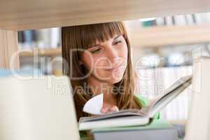 Student in library - happy woman read book