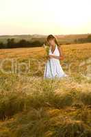 Romantic brunette woman in sunset corn field