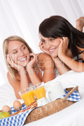 Blond woman and brunette having breakfast together