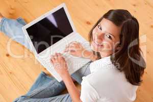 Young female teenager with laptop sitting