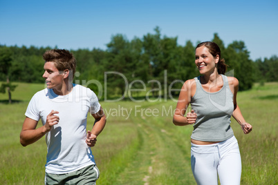 Young couple jogging outdoors in spring nature