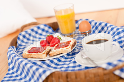 Homemade breakfast on wicker tray with checked teacloth