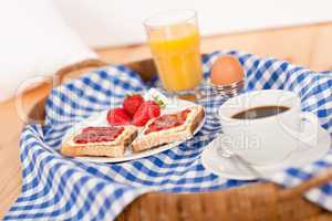 Homemade breakfast on wicker tray with checked teacloth