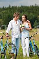 Romantic young couple walking with old bike