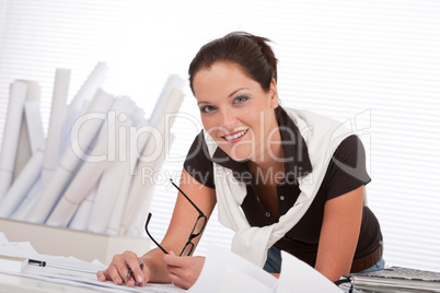 Young female architect with plans at the office