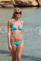 Attractive blond woman by the sea in bikini