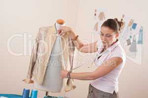 Female fashion designer taking measurement