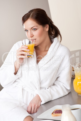 Young woman enjoying orange juice  in kitchen