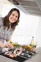Cook - plus size woman grill fish in kitchen