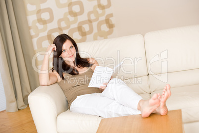 Young happy woman read book on sofa