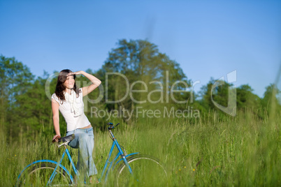 Woman with old-fashioned bike in summer meadow