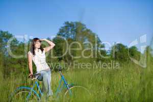 Woman with old-fashioned bike in summer meadow