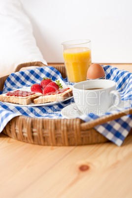 Homemade breakfast on wicker tray with checked teacloth