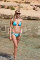Attractive blond woman by the sea in bikini