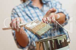 Home improvement: Woman holding paint brush and can