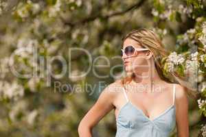 Spring - Young woman under blossom tree in orchard