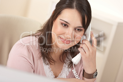 Portrait of young businesswoman on phone at office