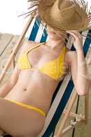 Beach - woman with straw hat in yellow bikini