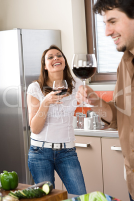 Young couple drink red wine in modern kitchen