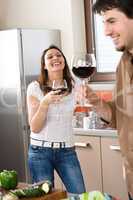 Young couple drink red wine in modern kitchen