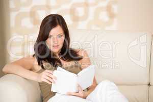 Young woman read book relaxing on sofa