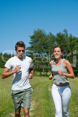 Young couple jogging outdoors in spring nature