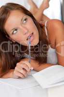 White lounge - Woman with notepad and pen thinking