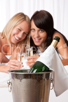 Two young women toasting with champagne