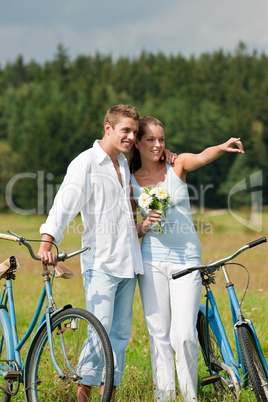 Romantic young couple walking with old bike